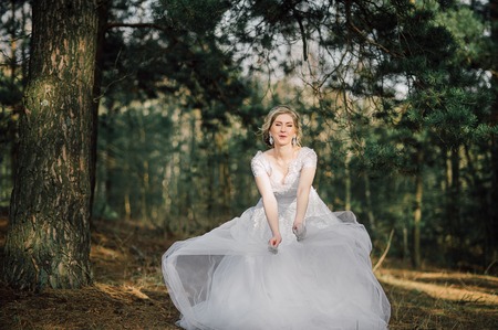 Beautiful bride woman portrait with bridal bouquet posing in her wedding dayの写真素材