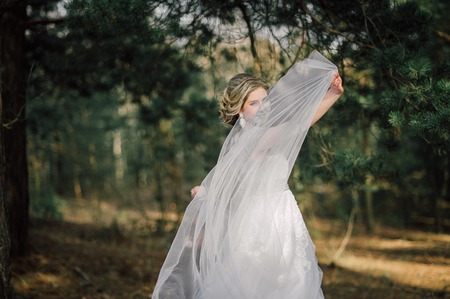 Beautiful bride woman portrait with bridal bouquet posing in her wedding dayの写真素材