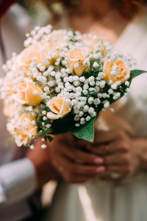 Beautiful wedding bouquet in hands of the bride. Peony rose, cotton, roses. Pink and Peach. Trendy and modern wedding flowers. Ideal photo for commercial.の写真素材