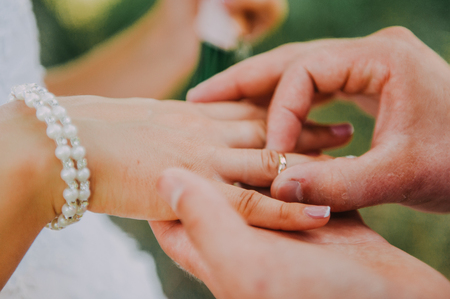 picture of man putting wedding ring on woman handの写真素材