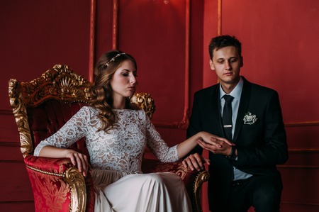 cute wedding couple in the interior of a classic studio decorated. hey kiss and hug each other