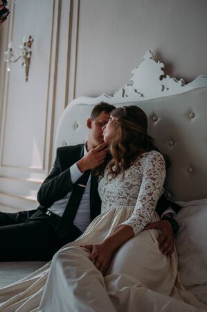 cute wedding couple in the interior of a classic studio decorated. hey kiss and hug each otherの写真素材
