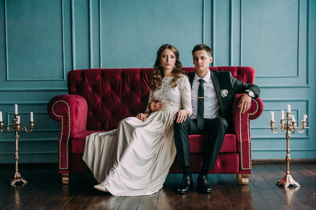 cute wedding couple in the interior of a classic studio decorated. hey kiss and hug each otherの写真素材