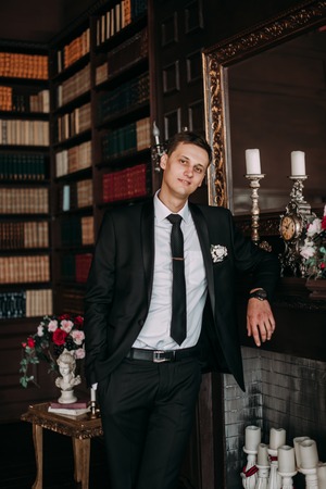 Groom in a suit holding buttonholeの写真素材