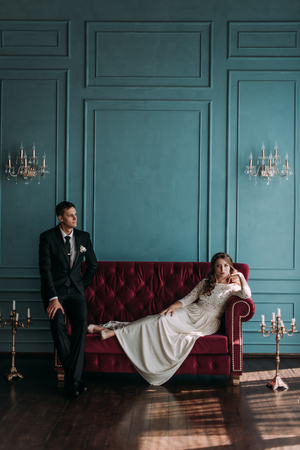 cute wedding couple in the interior of a classic studio decorated. hey kiss and hug each otherの写真素材