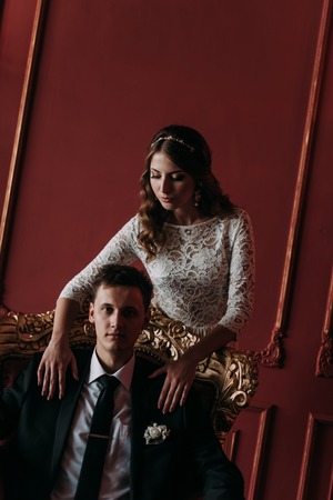 cute wedding couple in the interior of a classic studio decorated. hey kiss and hug each other