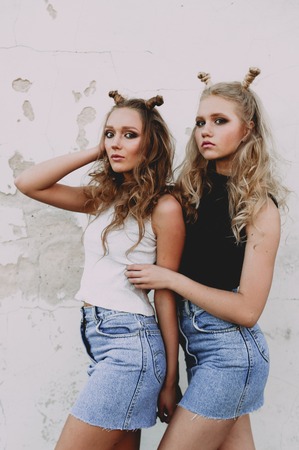 lifestyle and people concept: Fashion portrait of two stylish girls best friends wearing jeans...