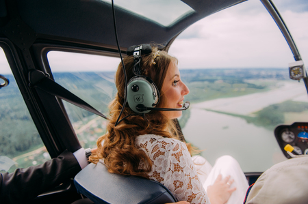 Happy beautiful newlyweds near the helicopterの写真素材