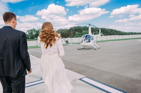 Happy beautiful newlyweds near the helicopterの写真素材