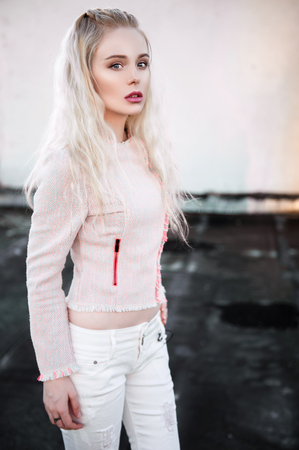 Outdoor portrait of young beautiful happy lady posing on street. Model wearing stylish clothes. Girl looking down. Female fashion. City lifestyle. Copy space.の写真素材