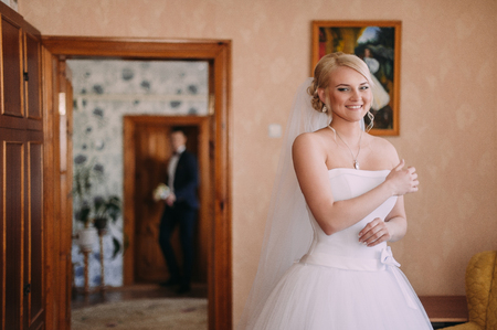 Portrait of beautiful bride with fashion veil posing at home at wedding morning. Makeup. Blondegirl with elegant hair styling. Wedding dress.の写真素材