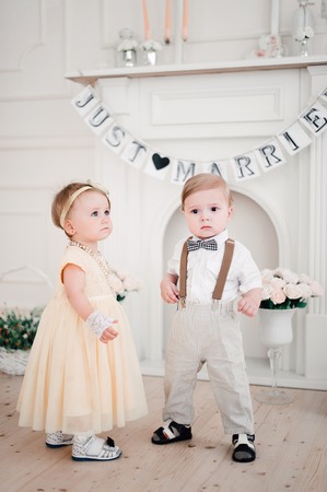 two babies - boy and girl dressed as bride and groomの写真素材