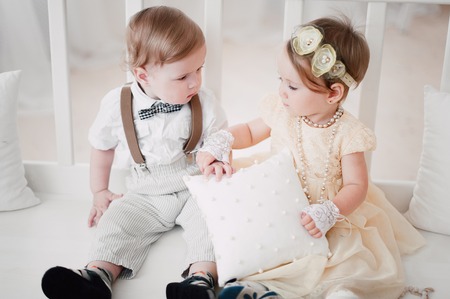 two babies - boy and girl dressed as bride and groomの写真素材