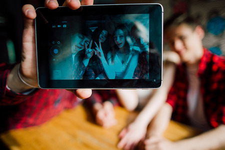 friends make selfie in a cafe. Two boys and two girls make selfie in cafeの写真素材