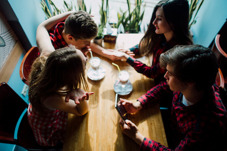Group of young friends hanging out at a coffee shop. Young men and women meeting in a cafe having fun.の写真素材
