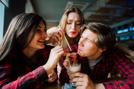 Group of young friends hanging out at a coffee shop. Young men and women meeting in a cafe having fun.の写真素材