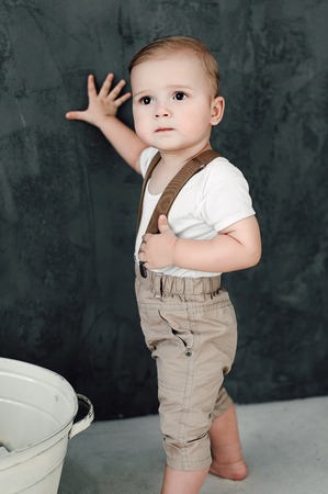 Portrait of lovely little boy happy smiling celebrating 1 year birthday. One year old european boy sitting on floor in studioの写真素材