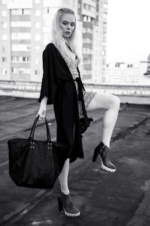 Outdoor portrait of young beautiful happy lady posing on street. Model wearing stylish clothes. Girl looking down. Female fashion. City lifestyle. Copy space.の写真素材