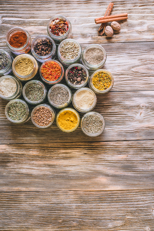 Various colorful kinds of spices on rustic wooden table, top viewの写真素材