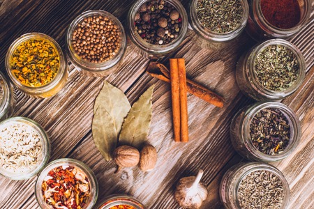 Various colorful kinds of spices on rustic wooden table, top viewの写真素材