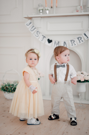 two babies - boy and girl dressed as bride and groomの写真素材