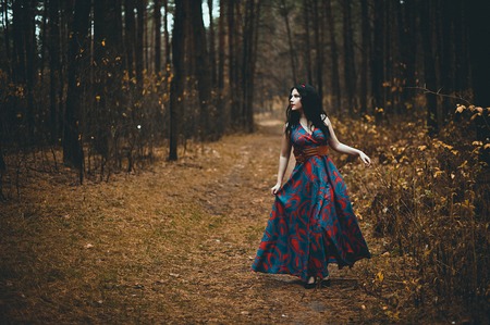 Red Hooded Woman Holding Apple Fairytale Portrait - Fairytale image of a beautiful  girl wearing a red hood near the forestの写真素材