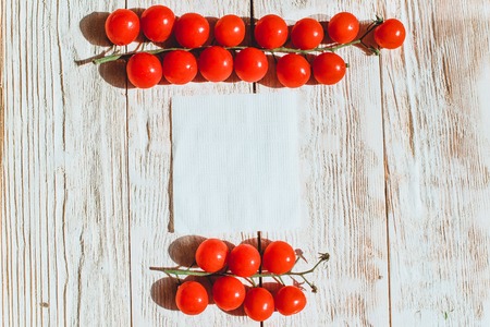 Cherry tomatoes on wooden table background with copy space, flat layの写真素材