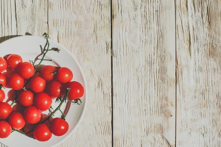 Cherry tomatoes on wooden table background with copy space, flat lay