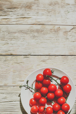 Cherry tomatoes on wooden table background with copy space, flat layの写真素材