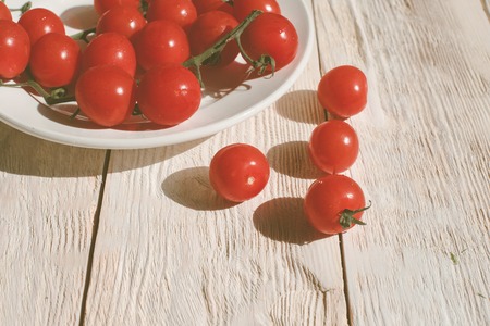 Cherry tomatoes on wooden table background with copy space, flat layの写真素材
