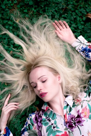 happy young blondie european woman on the grassの写真素材