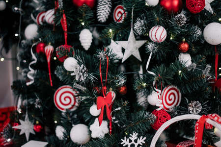 decorating christmas tree at home. Ornament close up on background of christmas tree with colorful...
