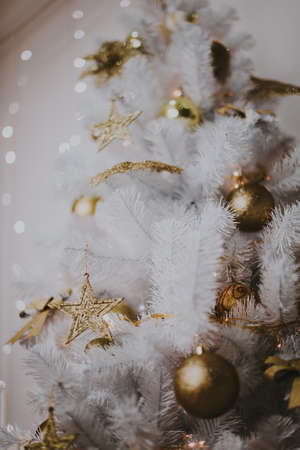 Decorating christmas tree at home. Ornament close up on background of christmas tree with colorful lights and toys, copy space for textの写真素材