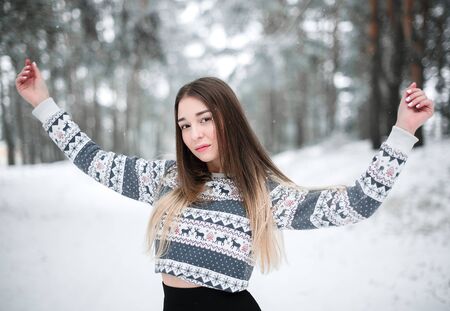 Winter portrait of young beautiful brunette woman wearing sweater. Snowing winter beauty fashion concept.の写真素材