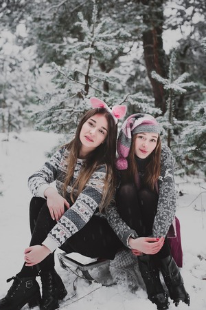 Two young teenage hipster girl friends together.Close up fashion portrait of two sisters hugs and...