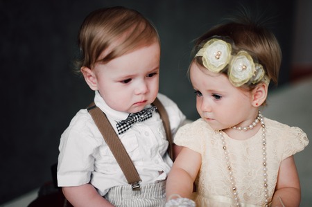 two babies - boy and girl dressed as bride and groomの写真素材