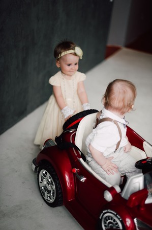 toddler - boy and girl playing with a toy carの写真素材