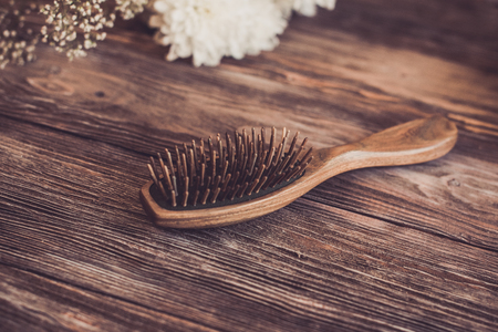 Haircare concept. Natural sandalwood comb closeup on wood backgroundの写真素材