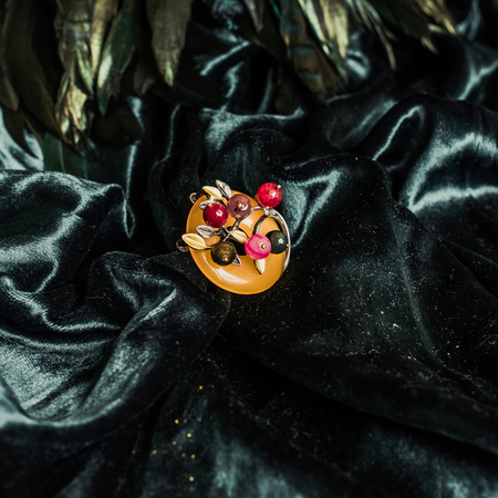 Vintage metal colorful brooch on velvet backgroundの写真素材