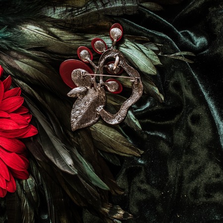 Vintage metal colorful brooch on velvet backgroundの写真素材