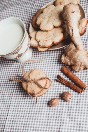 Close up of homemade ginger cookies, cinnamon, ginger on a wooden table. Copy space. Vintage toned image, flat layの写真素材