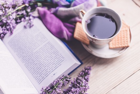 Morning cup of tee, cookies, and lilac flower on wooden table from above. Beautiful breakfast. Flat...
