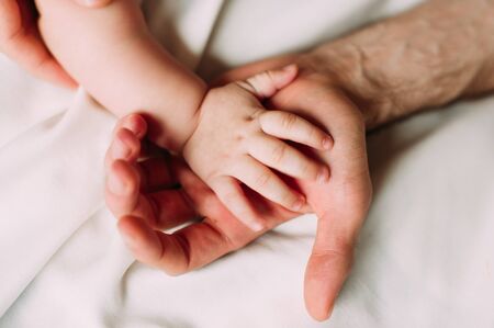 Portrait of loving father with baby boy 4-6 months his son at home on white
