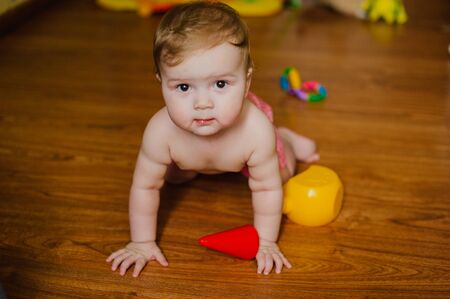 Smiling baby boy playing with toys in his room