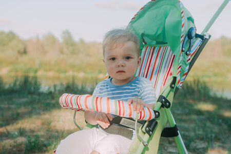 beautiful baby sitting in a pram outdoors