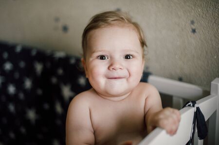 Baby boy sitting in the crib
