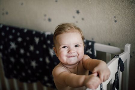Baby boy sitting in the cribの写真素材