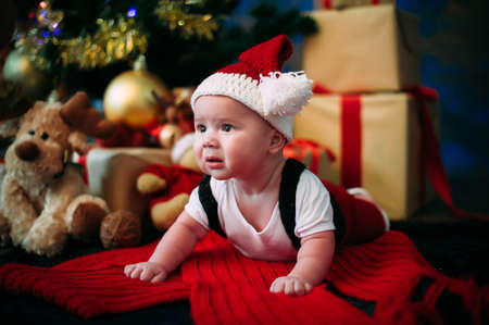 New Year's Concept. Adorable little boy near a Christmas tree with presents.  new year