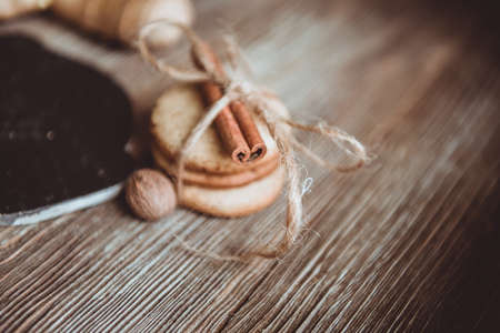 Close up of homemade ginger cookies, cinnamon, ginger on a wooden table. Copy space. Vintage toned image, flat layの写真素材