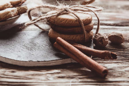 Close up of homemade ginger cookies, cinnamon, ginger on a wooden table. Copy space. Vintage toned image, flat layの写真素材
